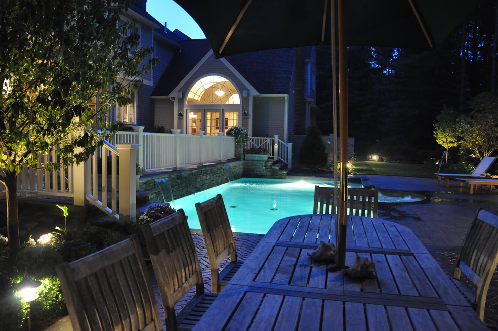 Example of a mid-sized classic backyard brick and rectangular lap hot tub design in Boston