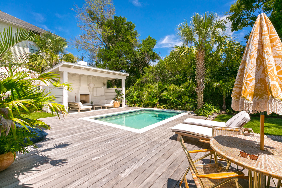 Idée de décoration pour un Abris de piscine et pool houses arrière minimaliste rectangle avec une terrasse en bois.