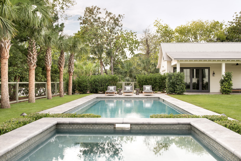 Ispirazione per una piscina stile marino rettangolare dietro casa con una vasca idromassaggio e pavimentazioni in pietra naturale