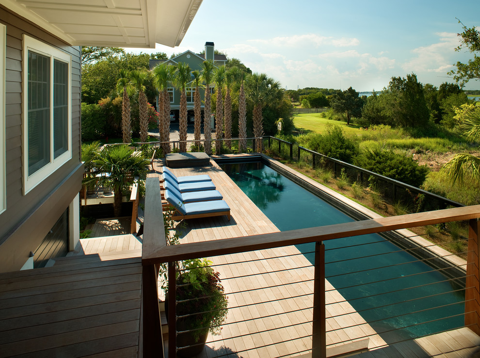 Cette photo montre un grand couloir de nage moderne rectangle avec un bain bouillonnant et une terrasse en bois.
