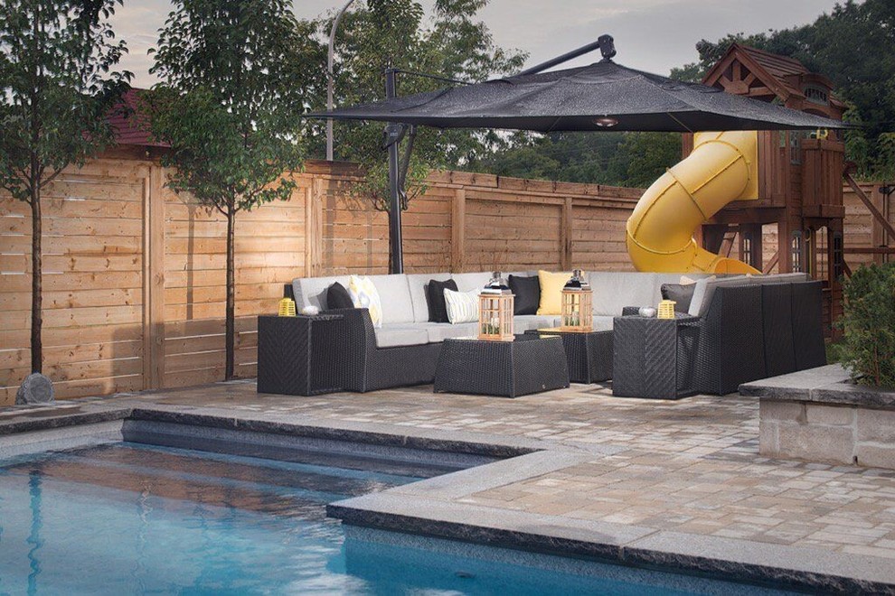 На фото: большой наземный бассейн произвольной формы на заднем дворе в стиле модернизм с покрытием из плитки и домиком у бассейна с