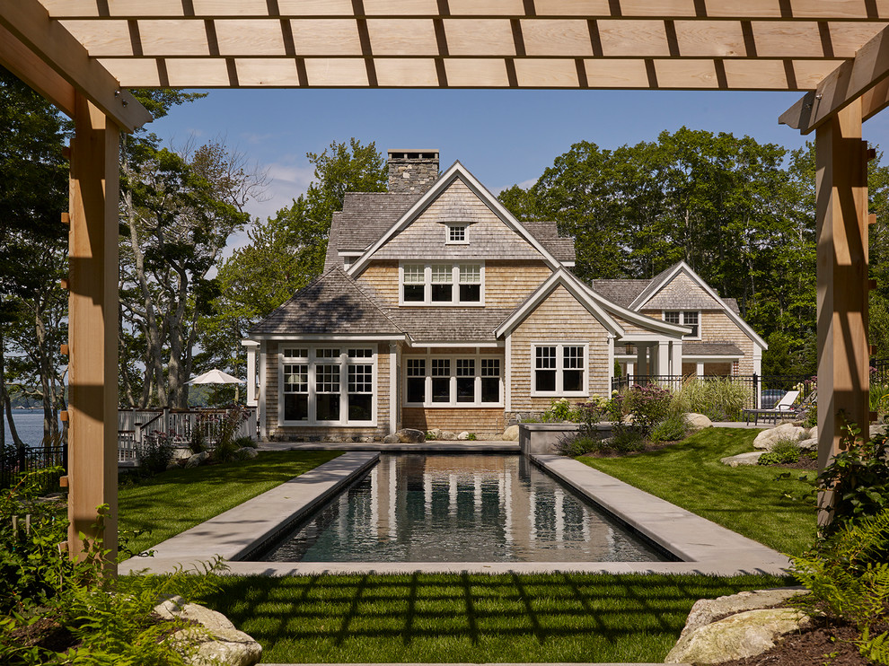 Modelo de piscina alargada clásica rectangular en patio lateral con adoquines de hormigón