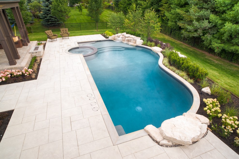 Foto de piscinas y jacuzzis naturales contemporáneos grandes a medida en patio trasero con suelo de hormigón estampado
