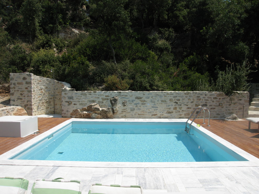 Cette image montre une piscine méditerranéenne avec une terrasse en bois.
