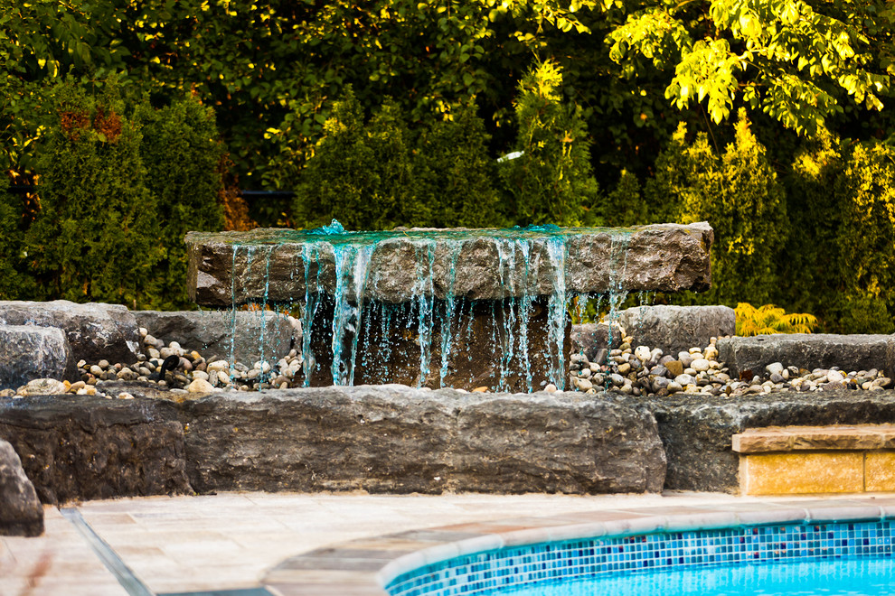 Idee per una grande piscina monocorsia contemporanea personalizzata dietro casa con fontane e pavimentazioni in cemento