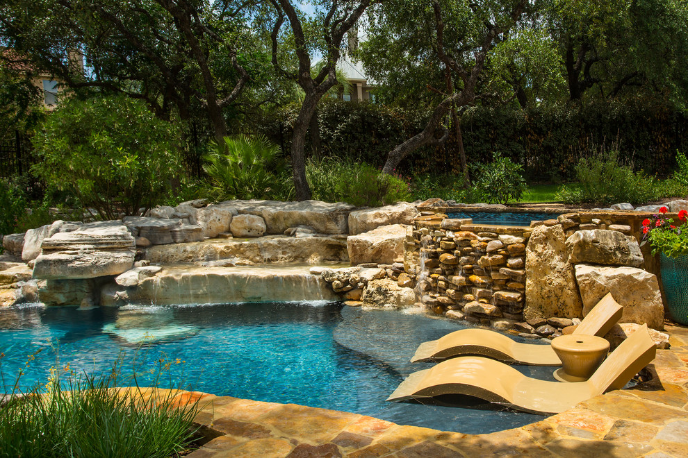 Immagine di una piscina naturale rustica personalizzata con una vasca idromassaggio e pavimentazioni in pietra naturale