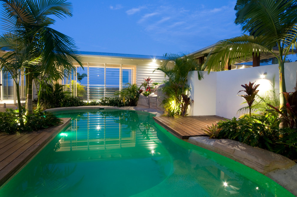Foto de piscina tropical con entablado