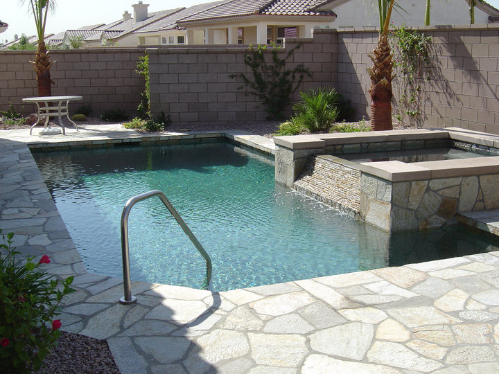 Mittelgroßer Pool hinter dem Haus in rechteckiger Form mit Natursteinplatten in Orange County