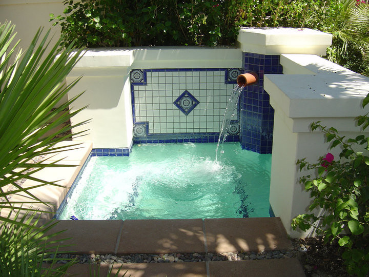 Diseño de piscinas y jacuzzis tropicales pequeños rectangulares en patio trasero con losas de hormigón