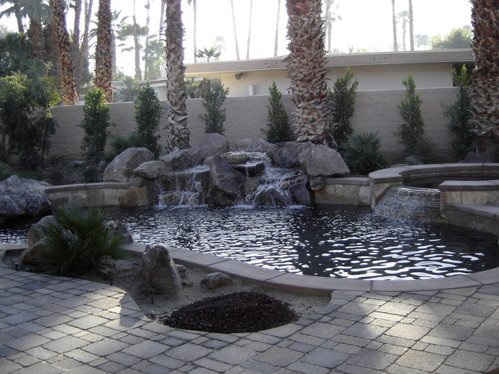 Diseño de piscinas y jacuzzis naturales exóticos pequeños rectangulares en patio trasero con adoquines de ladrillo