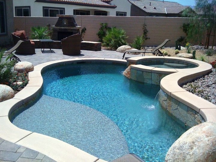 Hot tub - mid-sized tropical backyard brick and custom-shaped natural hot tub idea in Orange County