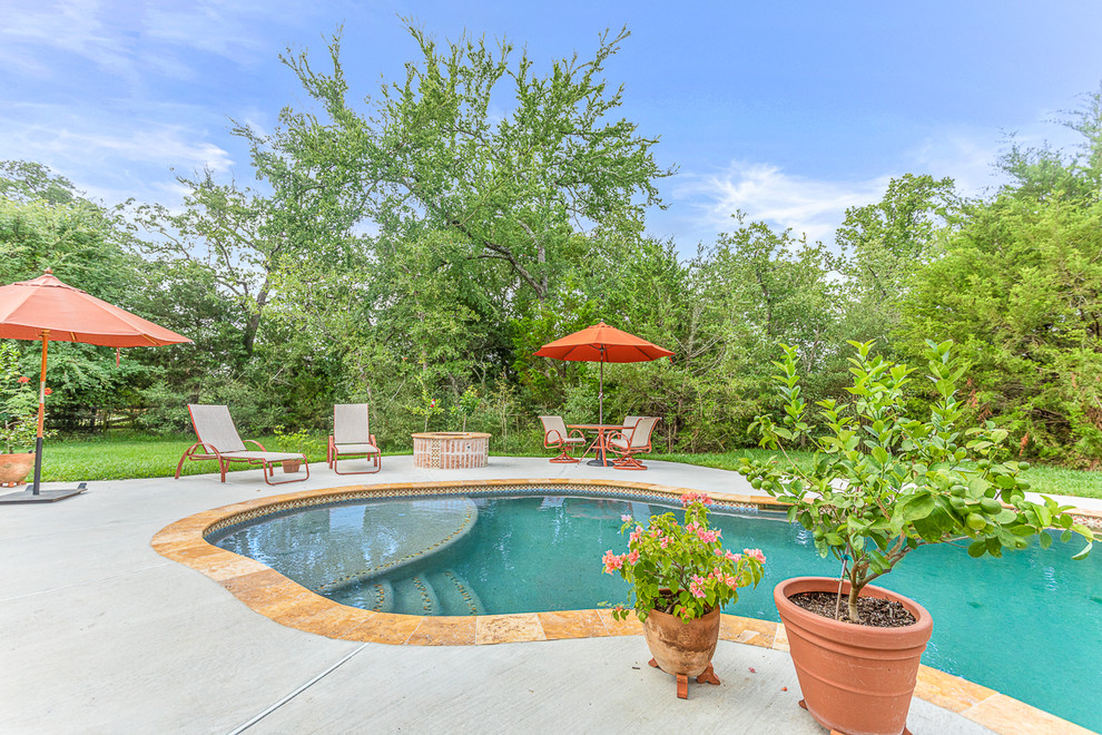 Imagen de piscina natural rústica de tamaño medio a medida en patio trasero con adoquines de piedra natural