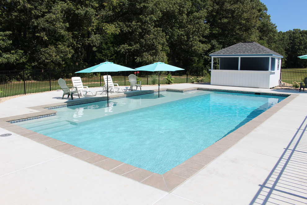 Inspiration pour une grande piscine naturelle et arrière design rectangle avec une dalle de béton.