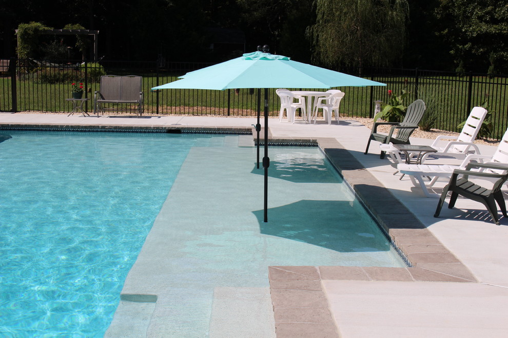 Пример оригинального дизайна: большой естественный, прямоугольный бассейн на заднем дворе в современном стиле с покрытием из бетонных плит