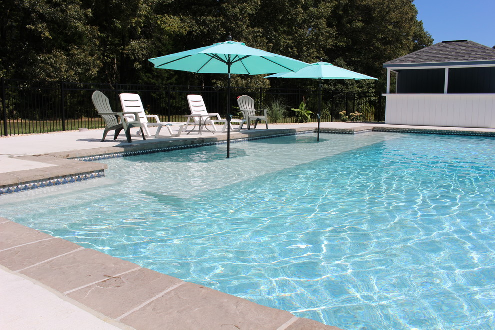 Aménagement d'une grande piscine naturelle et arrière contemporaine rectangle avec une dalle de béton.