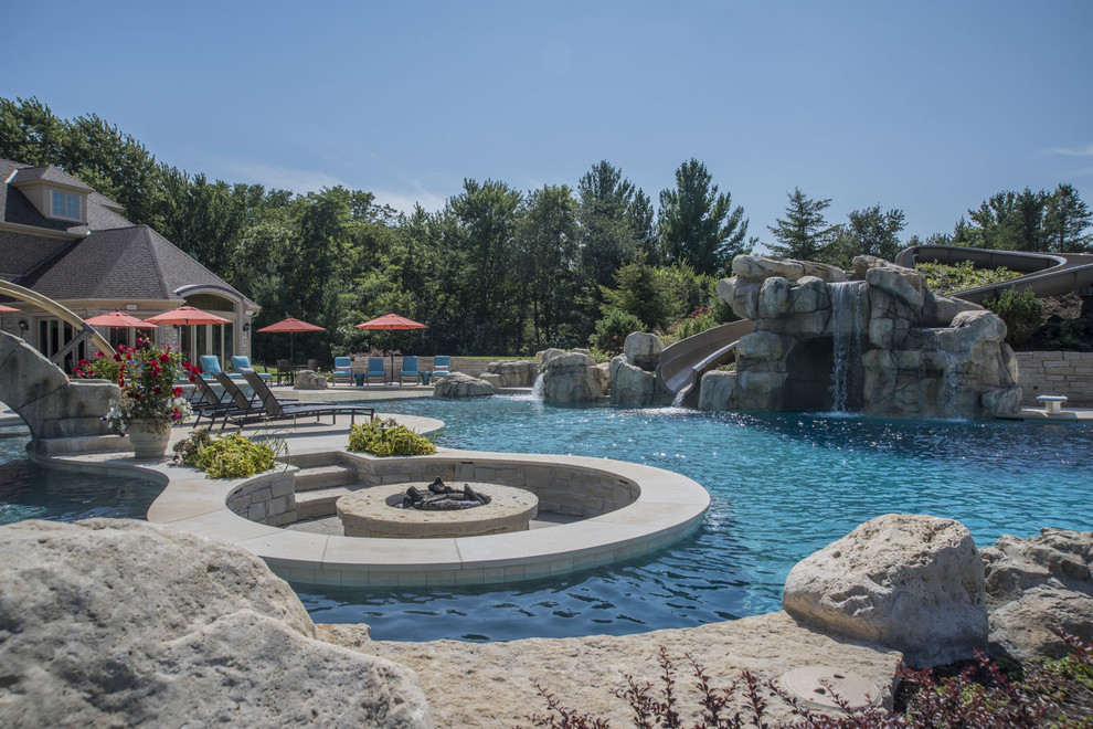 Ejemplo de piscinas y jacuzzis infinitos extra grandes a medida en patio trasero con adoquines de piedra natural