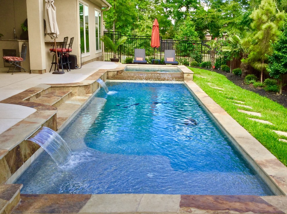Imagen de piscinas y jacuzzis alargados tradicionales de tamaño medio rectangulares en patio trasero con adoquines de piedra natural