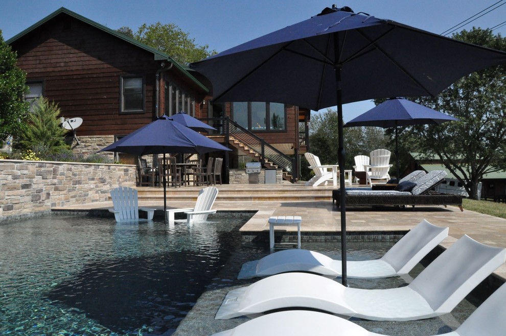 Immagine di una piscina moderna personalizzata di medie dimensioni e dietro casa con una vasca idromassaggio e pavimentazioni in pietra naturale