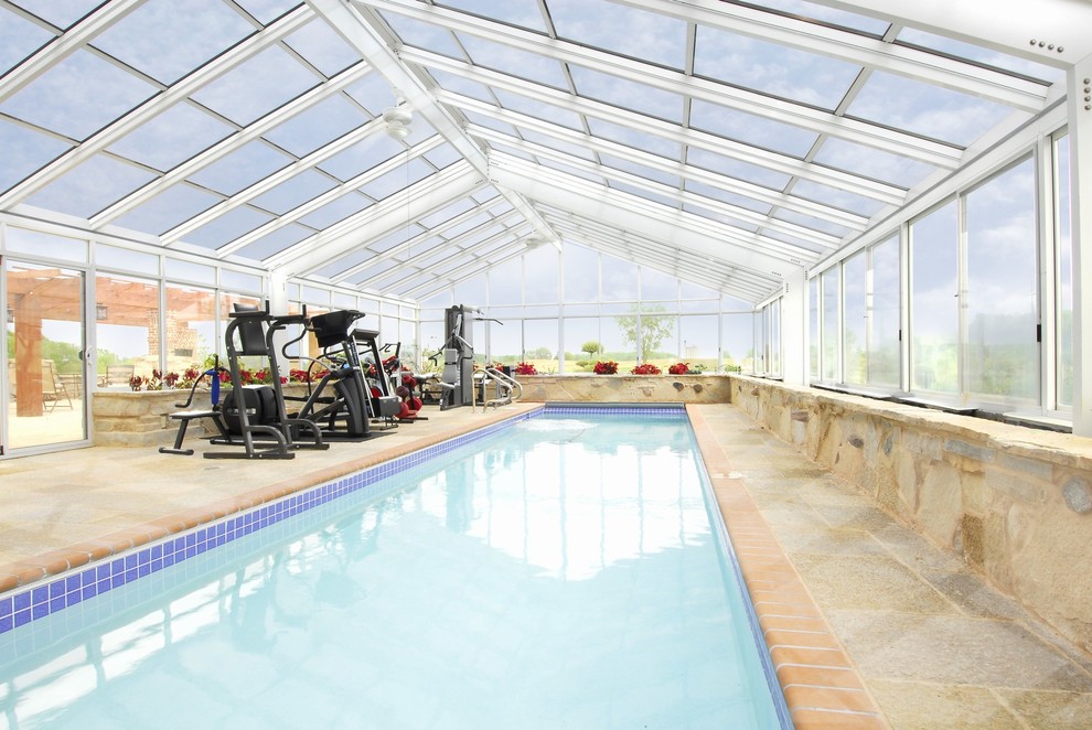 Imagen de piscina alargada tradicional renovada grande interior y rectangular con suelo de baldosas