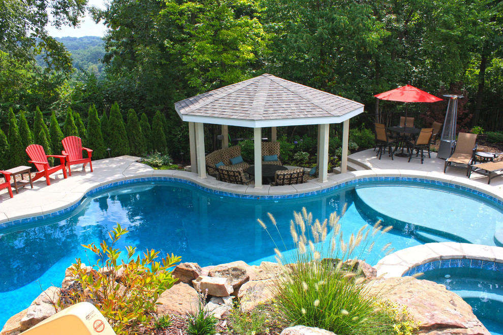 Inspiration for a large rustic backyard concrete and custom-shaped pool remodel in St Louis