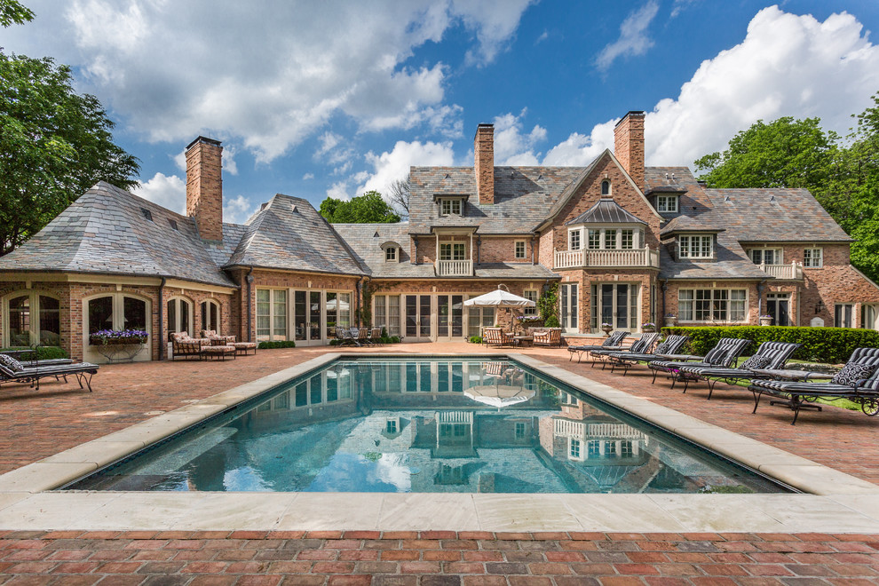Immagine di una piscina classica rettangolare dietro casa con pavimentazioni in mattoni