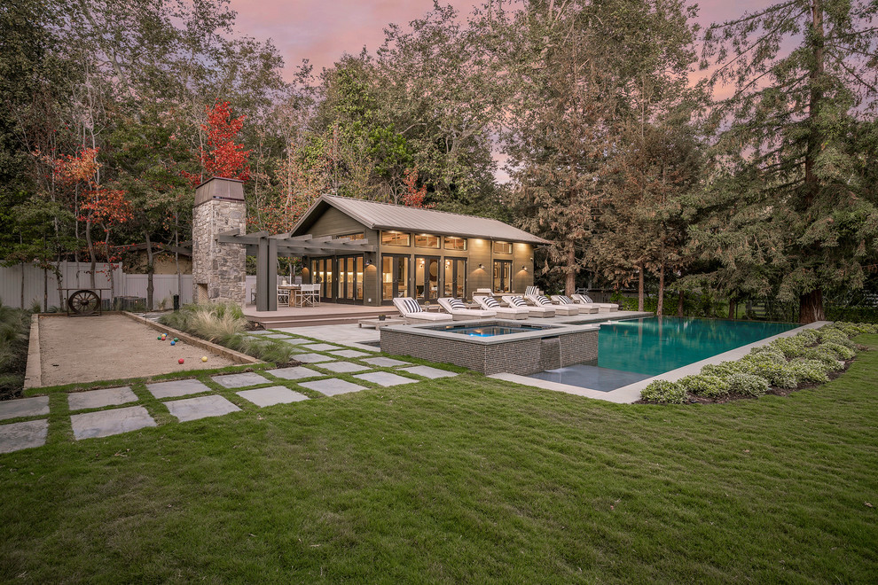 Diseño de casa de la piscina y piscina alargada contemporánea extra grande rectangular en patio trasero con adoquines de piedra natural