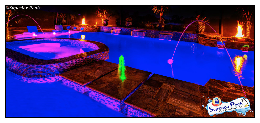 Inspiration for a huge tropical backyard custom-shaped pool remodel in Tampa with decking