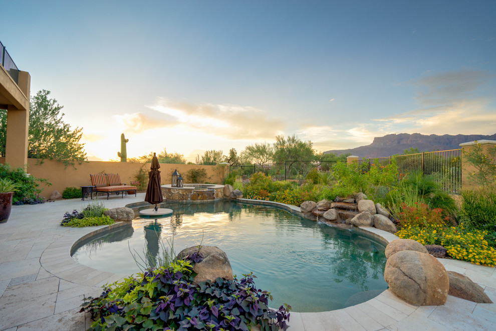Modelo de piscinas y jacuzzis naturales de estilo americano tipo riñón en patio trasero con adoquines de piedra natural
