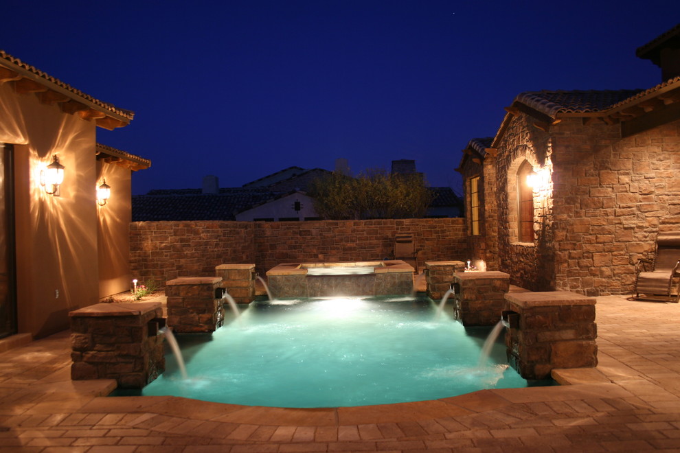 Foto de piscinas y jacuzzis alargados de estilo americano de tamaño medio a medida en patio trasero con adoquines de ladrillo