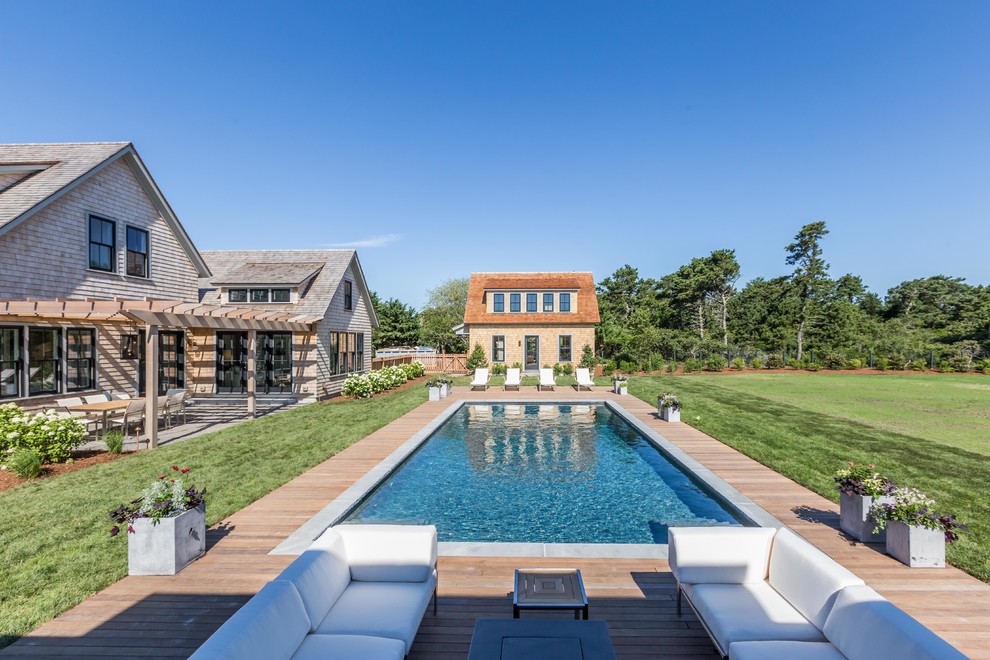Aménagement d'un Abris de piscine et pool houses arrière bord de mer rectangle avec une terrasse en bois.
