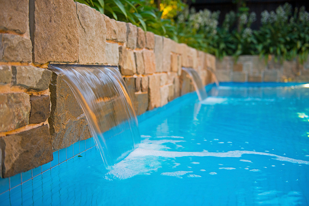 Idee per una piccola piscina monocorsia minimal rettangolare dietro casa con pavimentazioni in pietra naturale e fontane