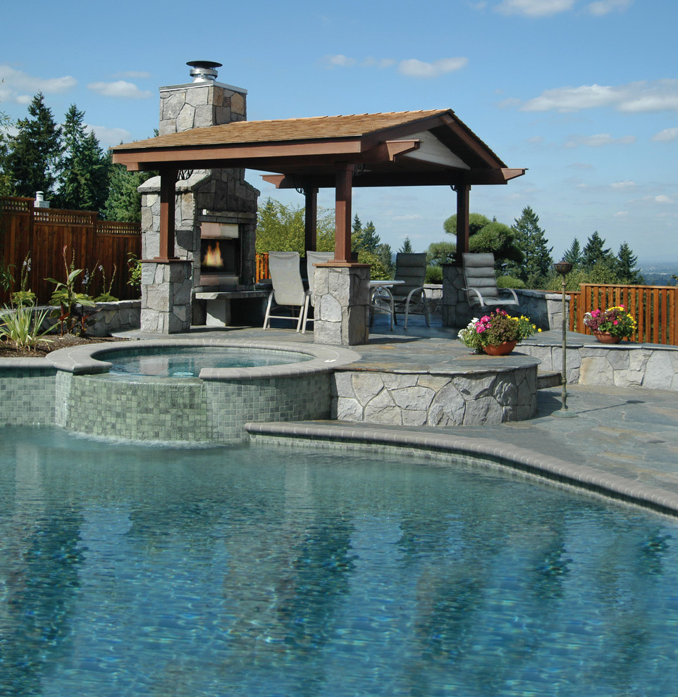 Foto de piscina clásica grande a medida en patio trasero con adoquines de piedra natural