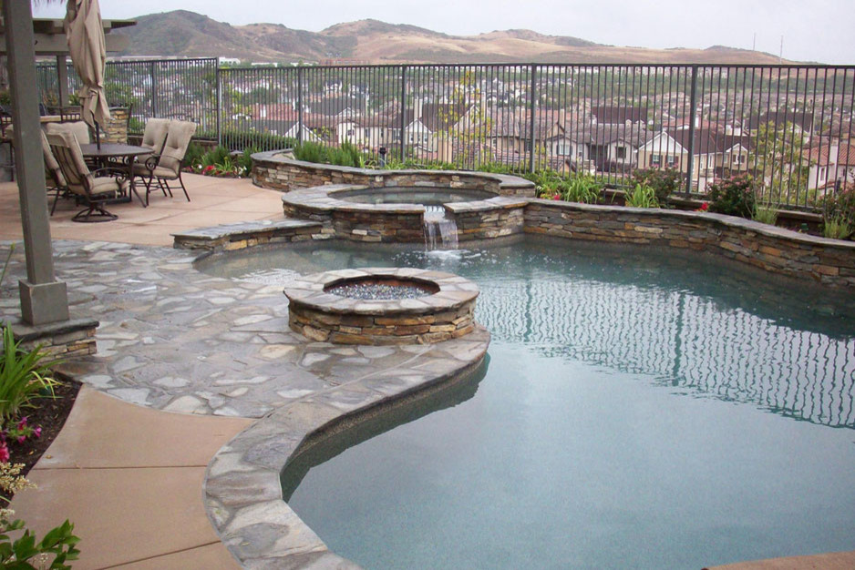 Foto de piscinas y jacuzzis alargados tradicionales de tamaño medio tipo riñón en patio trasero con losas de hormigón