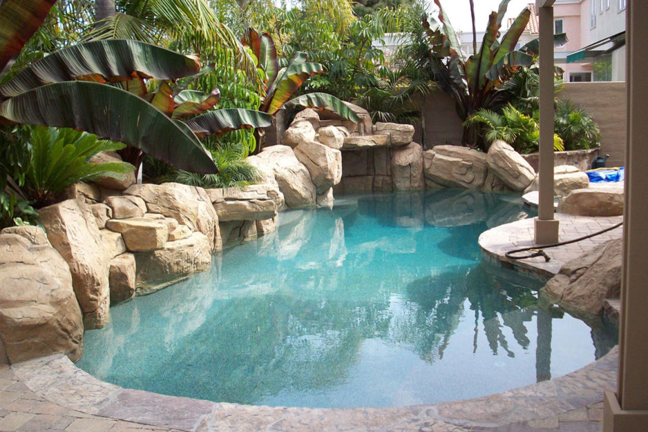 Modelo de piscina con fuente alargada tradicional de tamaño medio tipo riñón en patio trasero con adoquines de ladrillo