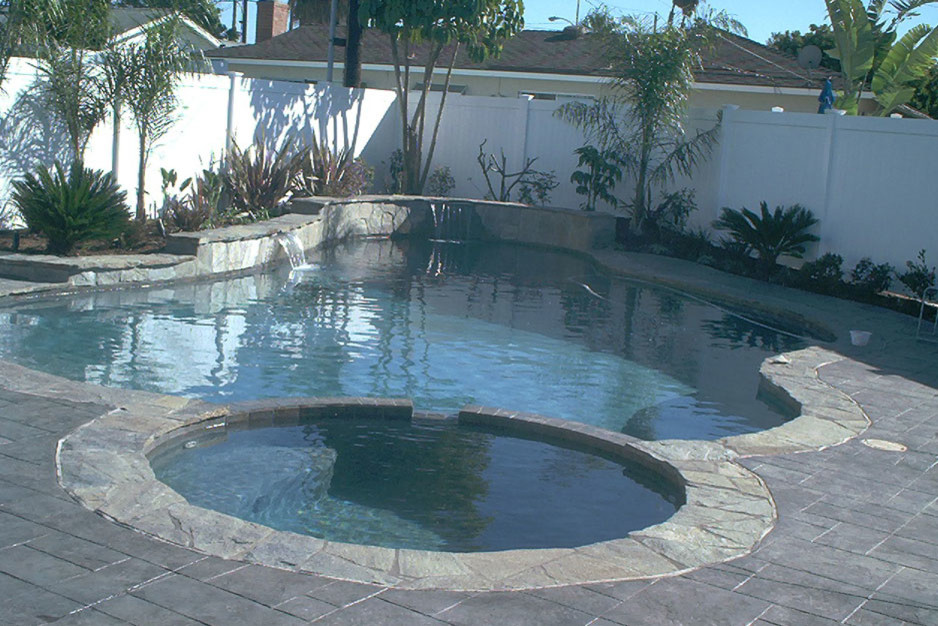 Esempio di una piscina monocorsia classica personalizzata di medie dimensioni e dietro casa con una vasca idromassaggio e pavimentazioni in cemento