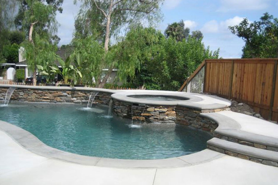 Foto di una piscina monocorsia chic a "C" di medie dimensioni e dietro casa con una vasca idromassaggio e lastre di cemento