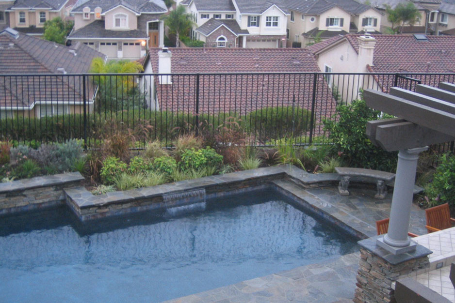 Ispirazione per una piscina monocorsia chic a "L" di medie dimensioni e dietro casa con fontane e pavimentazioni in pietra naturale