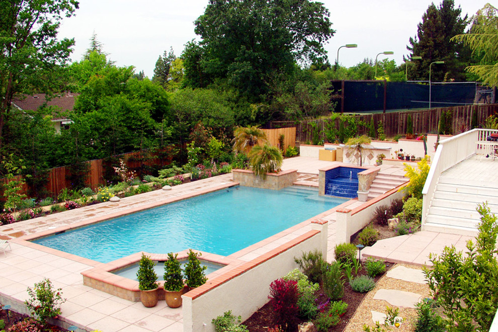 Foto de piscinas y jacuzzis alargados mediterráneos grandes rectangulares en patio trasero con suelo de baldosas