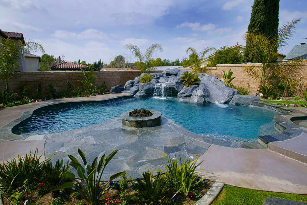 Großer Moderner Schwimmteich hinter dem Haus in individueller Form mit Wasserrutsche und Natursteinplatten in Orange County