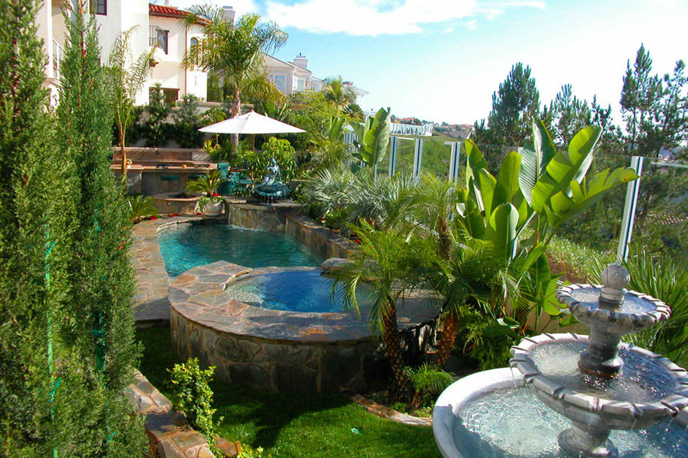 Inspiration for a small tropical backyard stone and rectangular lap hot tub remodel in Orange County