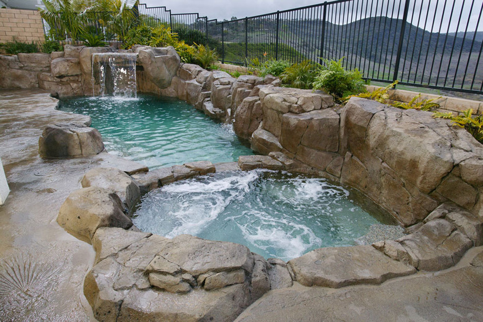 Cette image montre une petite piscine naturelle et arrière traditionnelle sur mesure avec un point d'eau et du béton estampé.