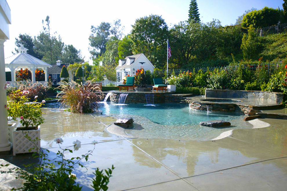 Inspiration for a large classic back custom shaped natural hot tub in Orange County with concrete slabs.