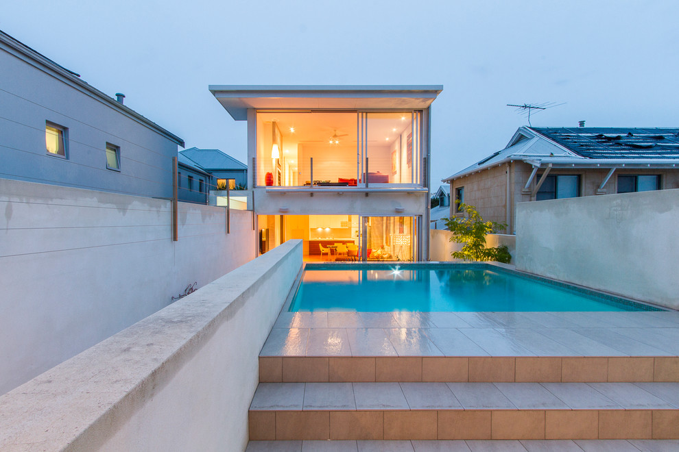 Ispirazione per una piscina contemporanea rettangolare dietro casa con piastrelle