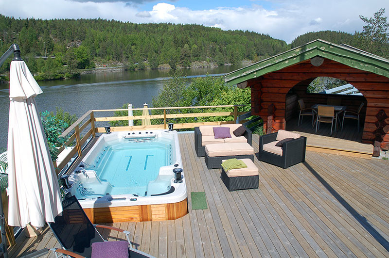 Réalisation d'une piscine arrière et hors-sol champêtre de taille moyenne et rectangle avec un bain bouillonnant et une terrasse en bois.