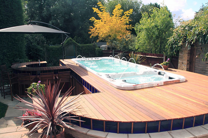Esempio di una piscina moderna rettangolare di medie dimensioni e dietro casa con una vasca idromassaggio e pedane