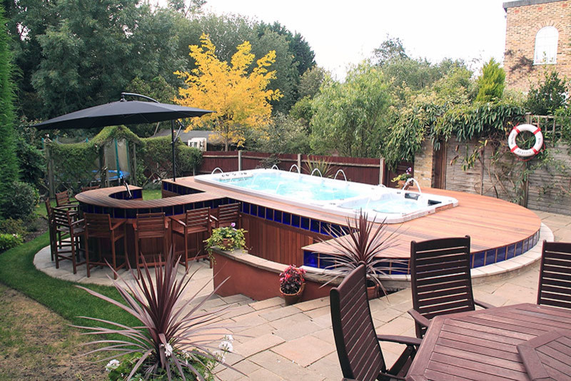 Idée de décoration pour une piscine arrière minimaliste de taille moyenne et rectangle avec un bain bouillonnant et une terrasse en bois.