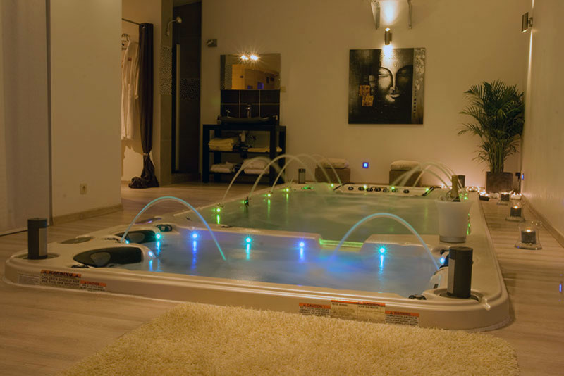 Photo of a medium sized world-inspired back rectangular hot tub in Orange County with tiled flooring.
