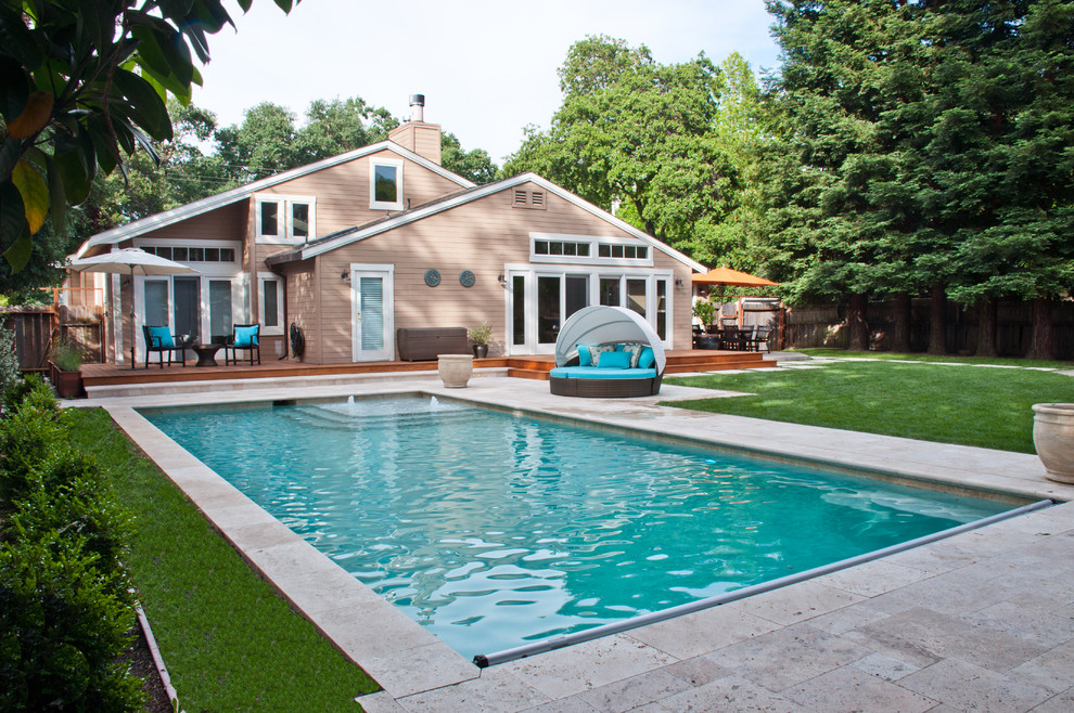 Diseño de piscina alargada minimalista grande rectangular en patio trasero con suelo de hormigón estampado
