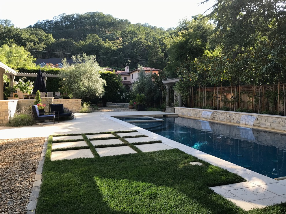Пример оригинального дизайна: большой спортивный, прямоугольный бассейн на заднем дворе в стиле модернизм с фонтаном и покрытием из каменной брусчатки