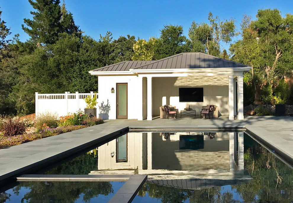Imagen de casa de la piscina y piscina alargada moderna grande rectangular en patio trasero con losas de hormigón